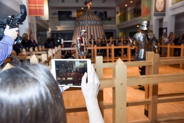 person with ipad recording 2 knights in armour performing a demonstation in the Tournament Gallery at the Royal Armouries
