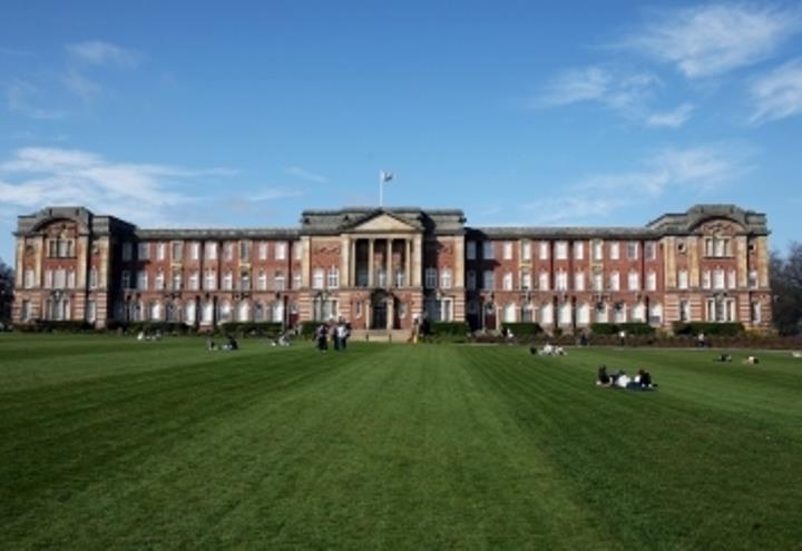 External view of the James Graham building with green grass in the foreground and a blue sky.