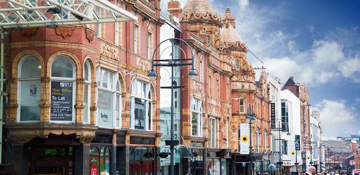 Leeds Briggate in the daytime with a blue sky.