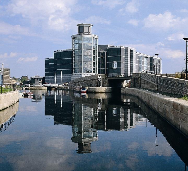 Daytime external view of the Royal Armouries with reflection in the canal.