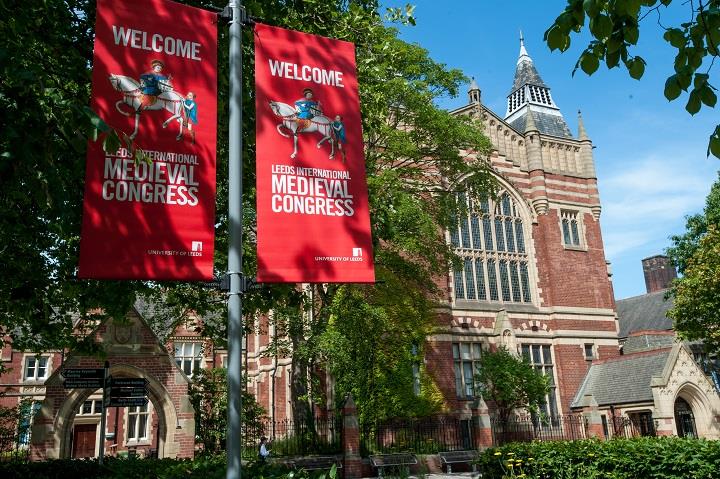 large red brick building with 2 red banner flags outside