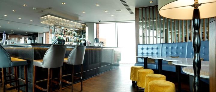 Bar area of the Sky Lounge during the day with yellow buffets.